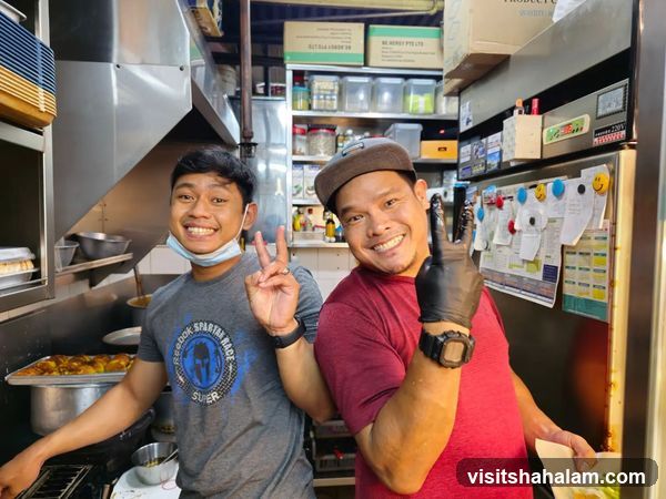 Two men posing in a kitchen