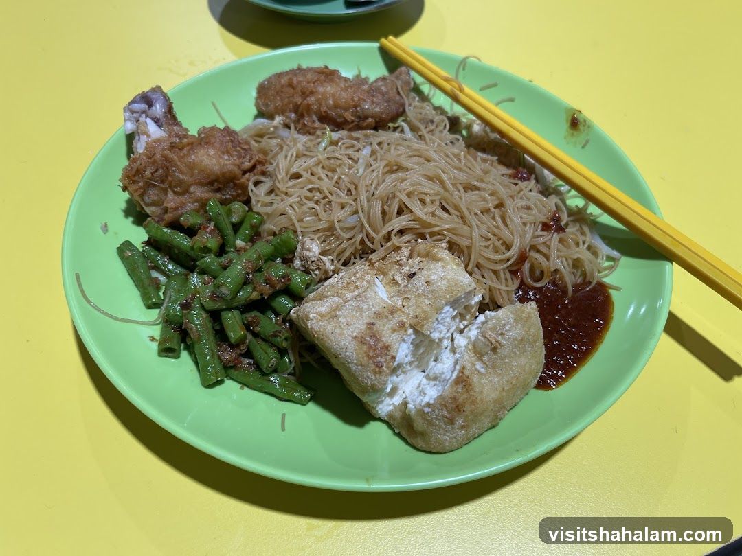 Plate of noodles with fried chicken and vegetables