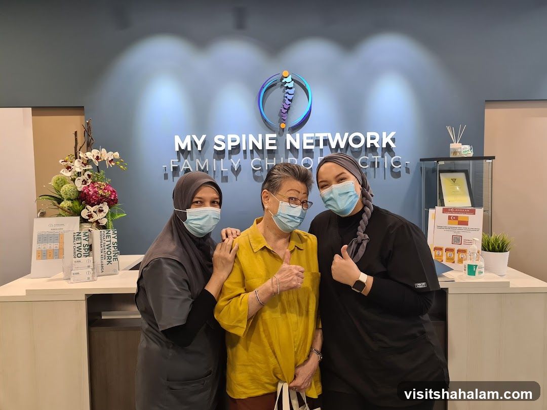 Three people posing in front of a clinic wall