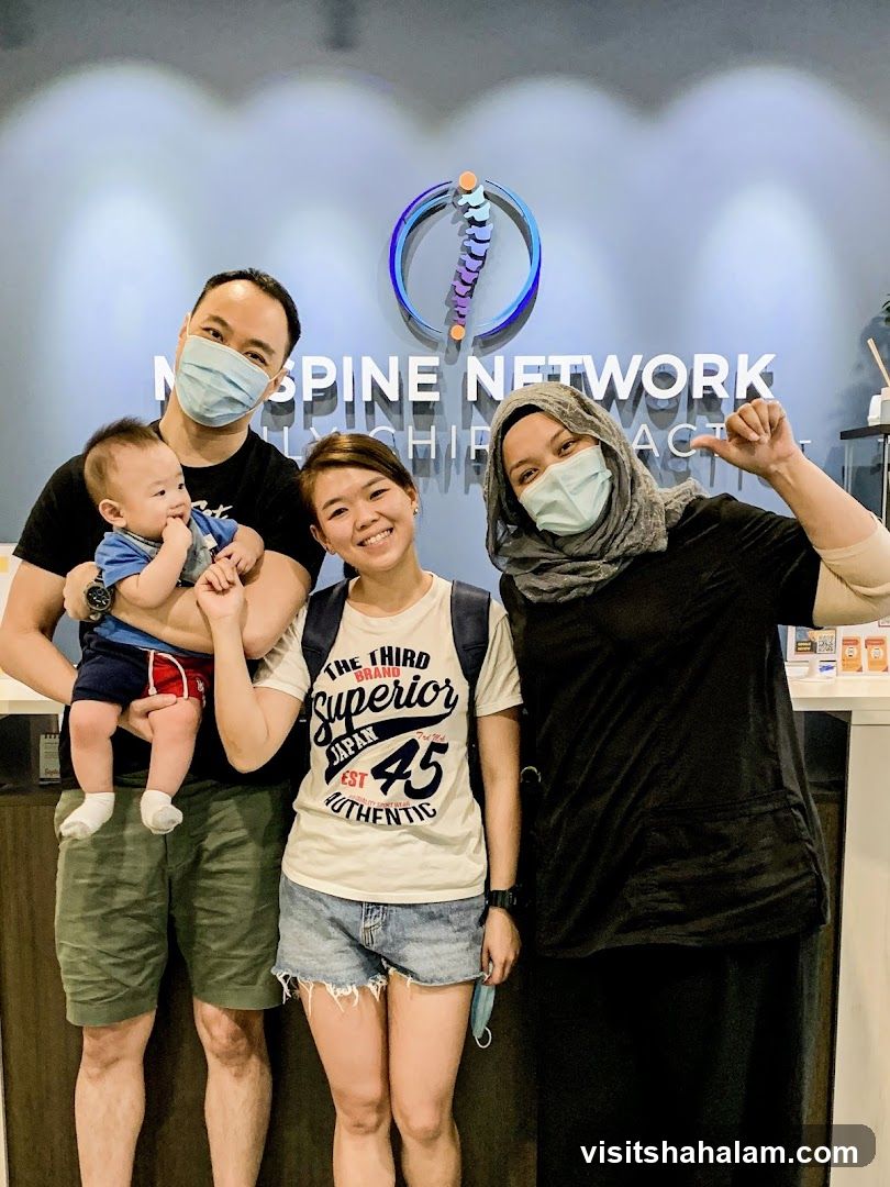 Family posing in front of Spine Network logo