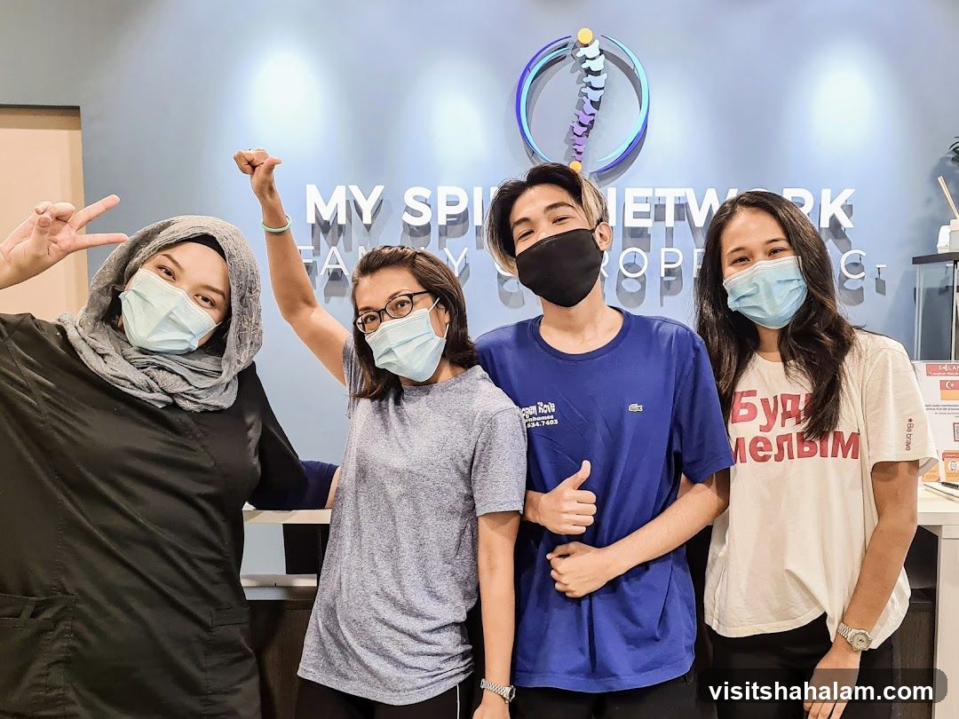 Four people posing in front of a sign