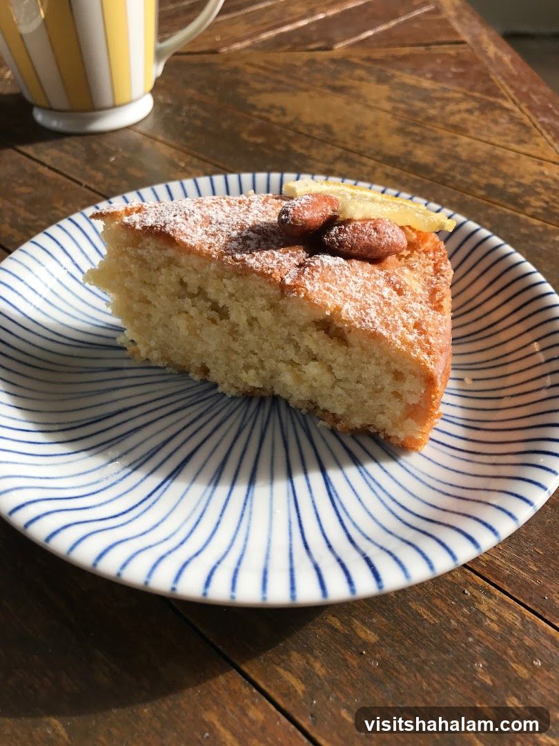 Slice of cake with almonds and lemon on a plate