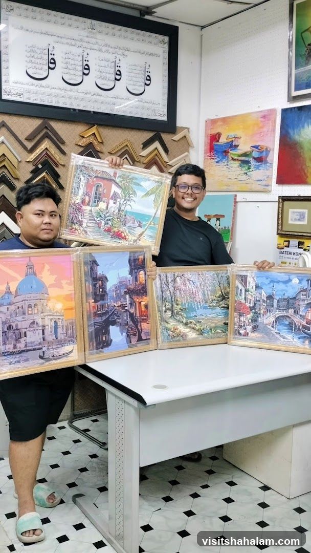 Two men holding framed paintings