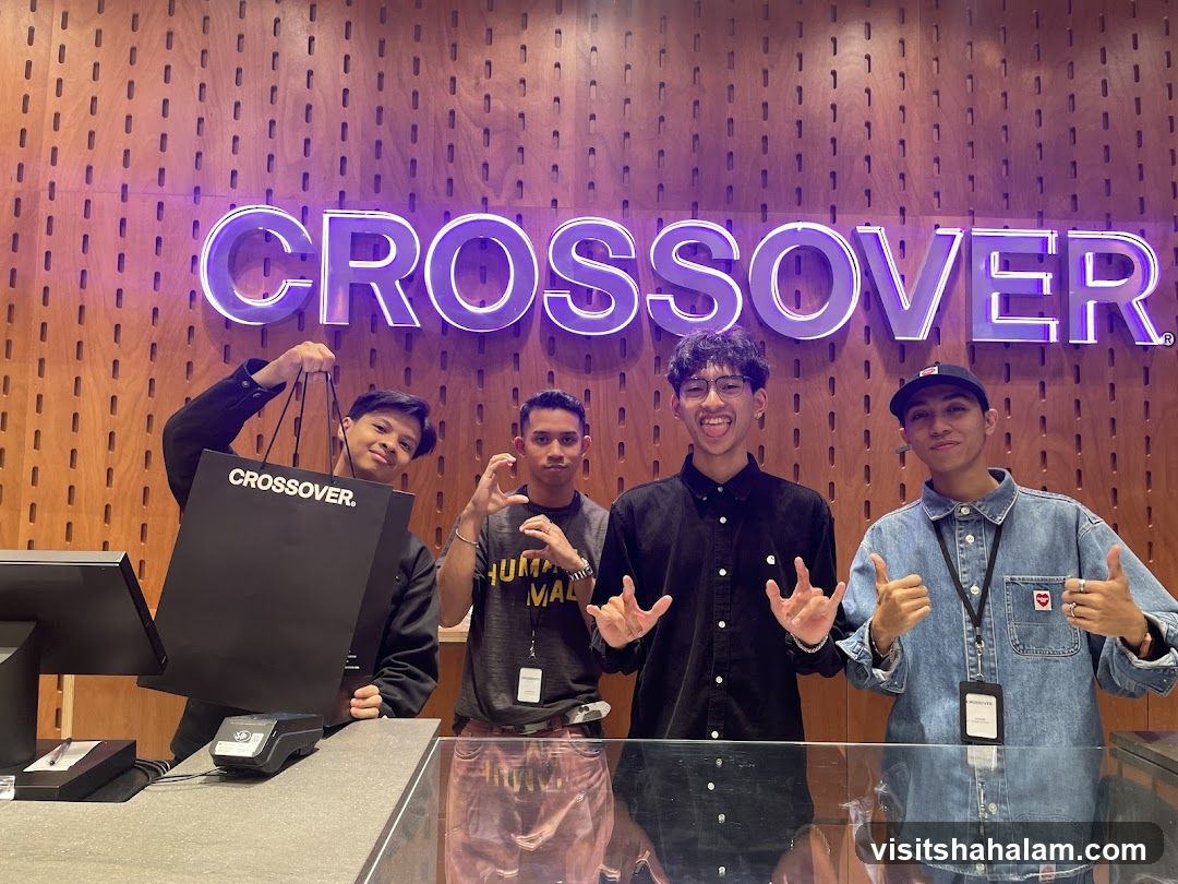 Four young men posing in front of a store sign