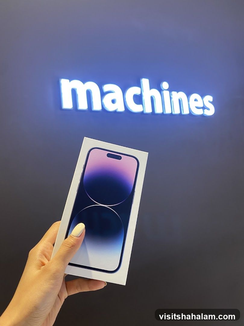 Person holding a new iPhone box in front of a store sign