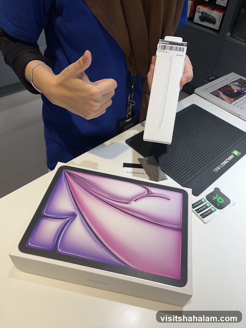 Person holding Apple Pencil box and iPad Air box