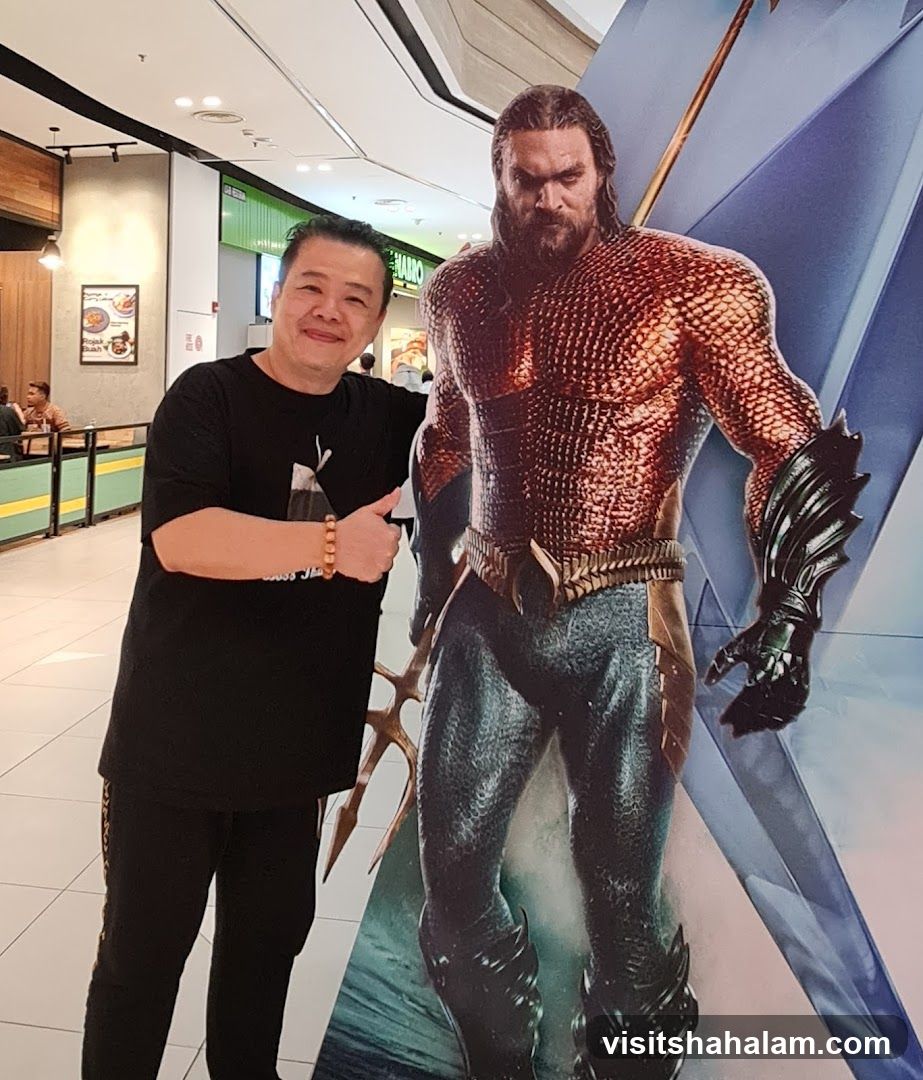 Man Posing with Aquaman Standee