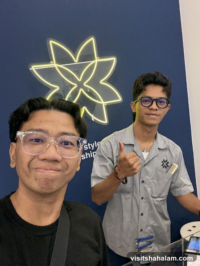 Two men posing in front of a neon sign