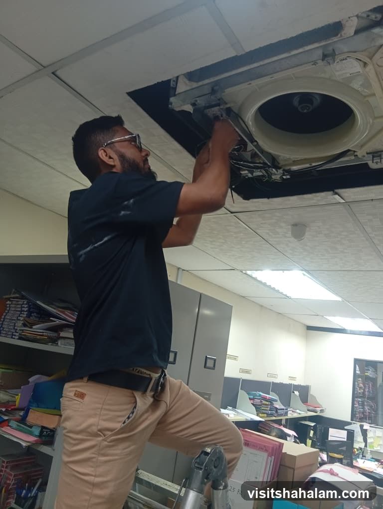 Technician working on ceiling AC unit