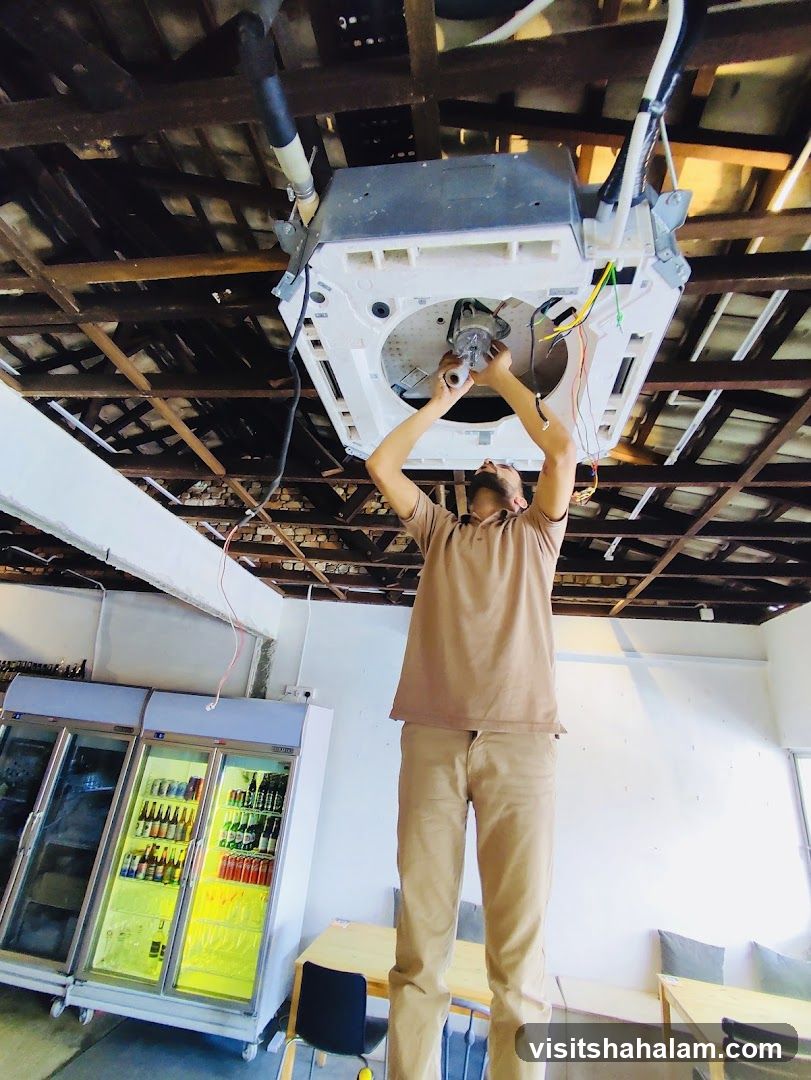 Technician working on ceiling AC unit