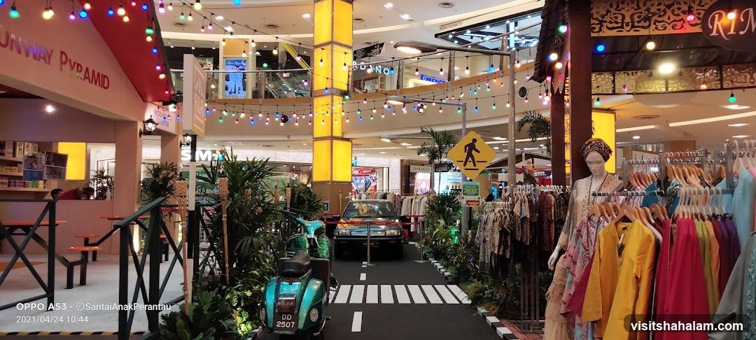 Mall display with clothing racks and vintage vehicles