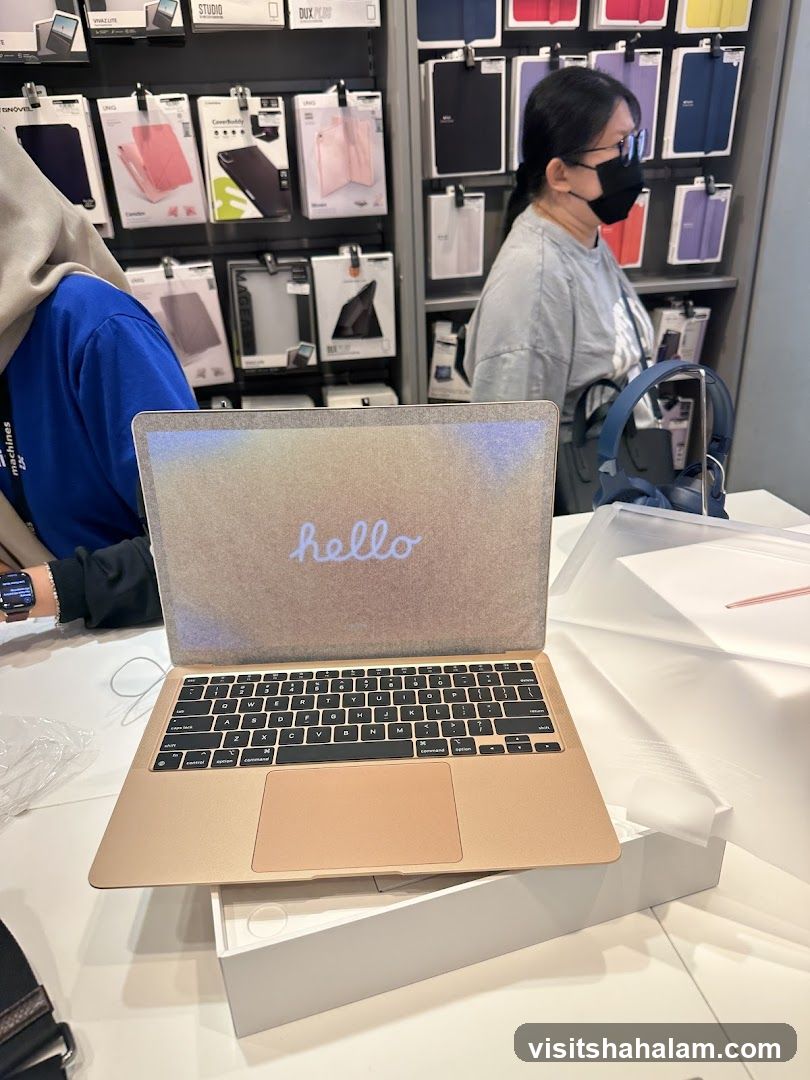 Gold MacBook Air with "hello" on screen