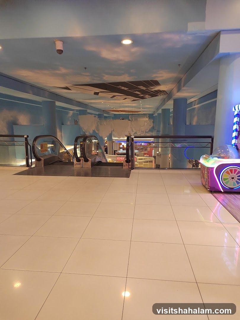 Indoor mall walkway with escalators and arcade game
