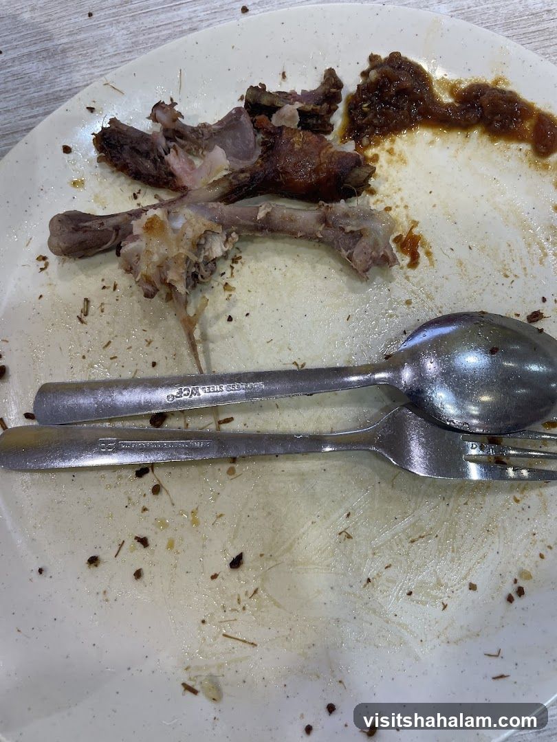 Dirty Plate with Leftover Food and Utensils