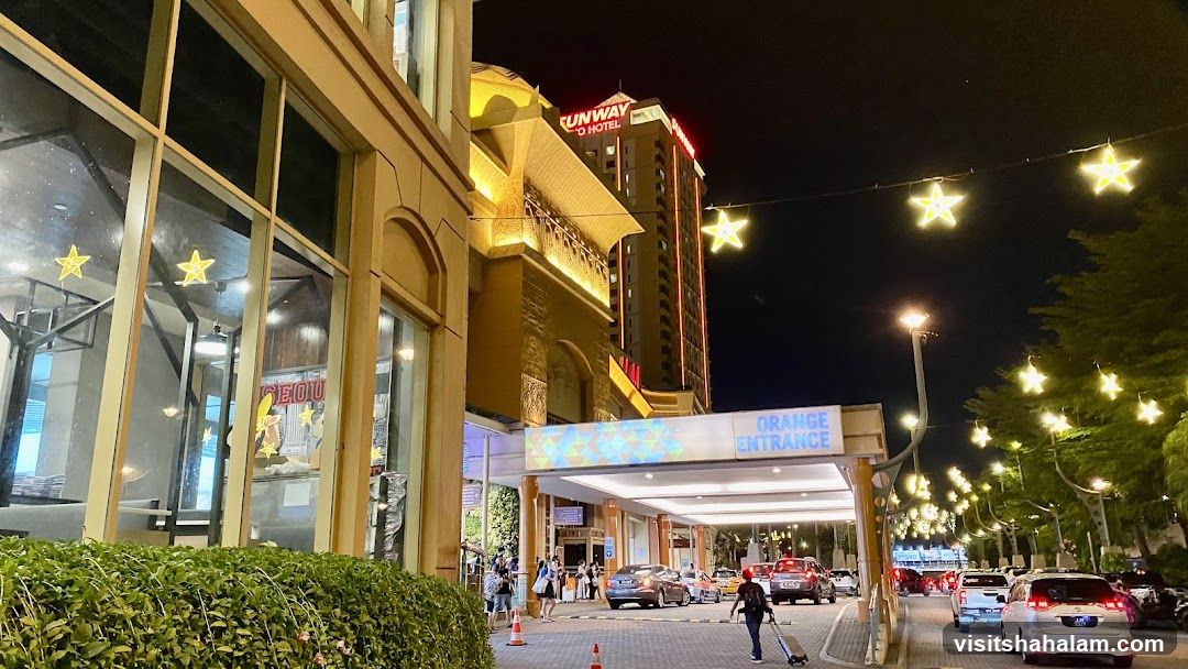 Nighttime view of a hotel entrance with festive lights