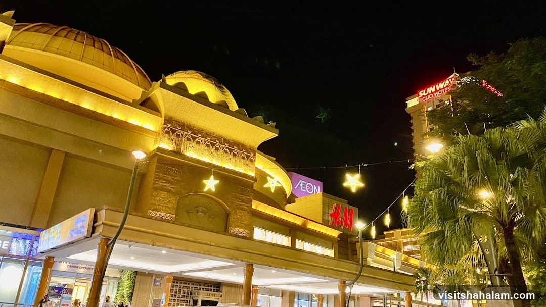 Night view of a shopping mall with illuminated facade and signage