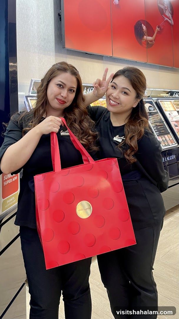 Two women holding a red bag