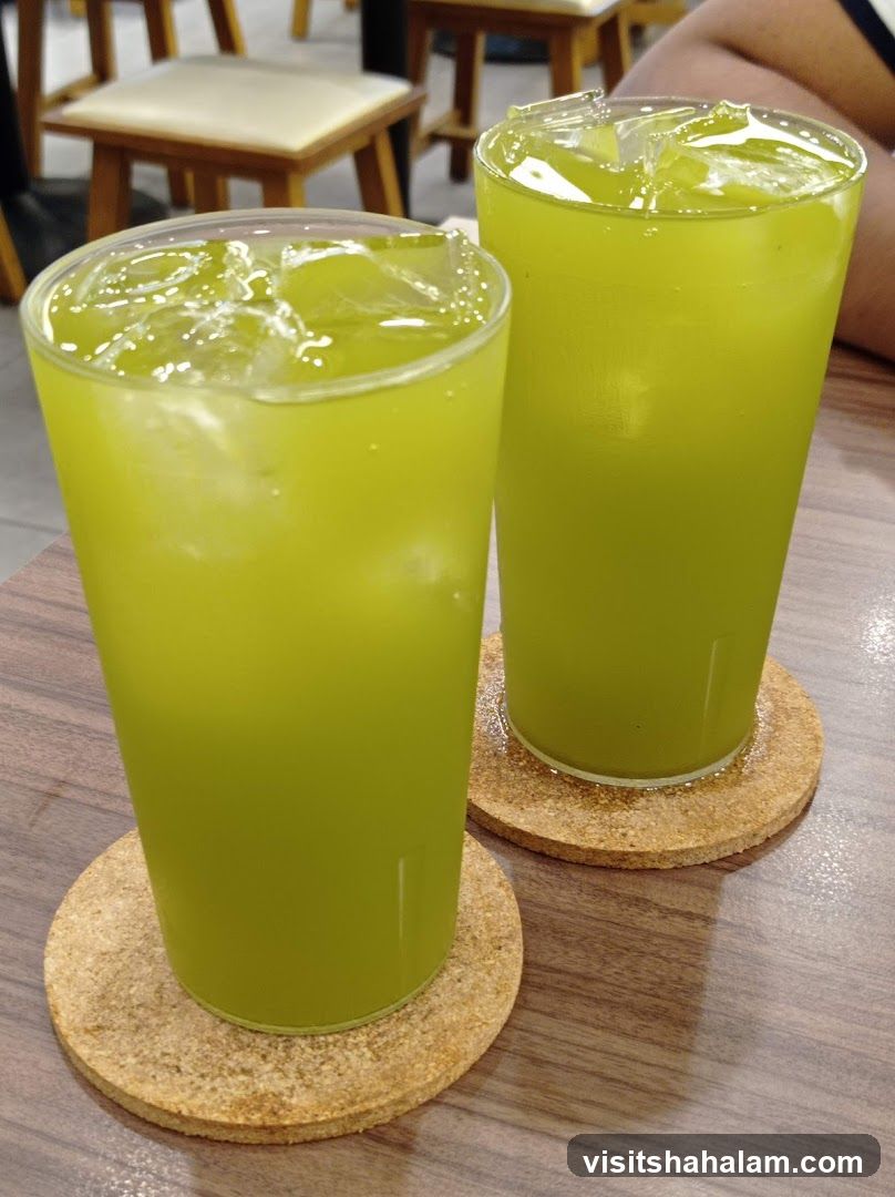 Two glasses of green juice with ice