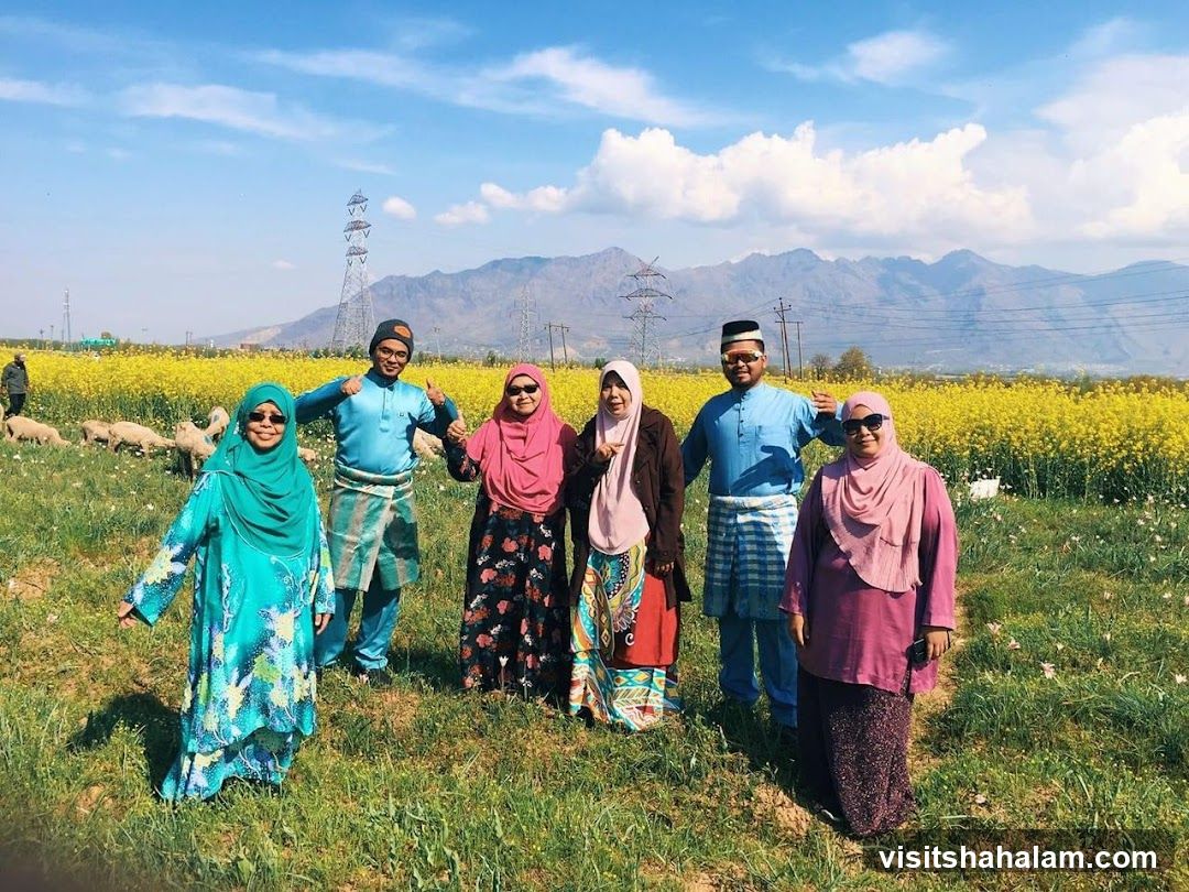 Group posing in a field of yellow flowers