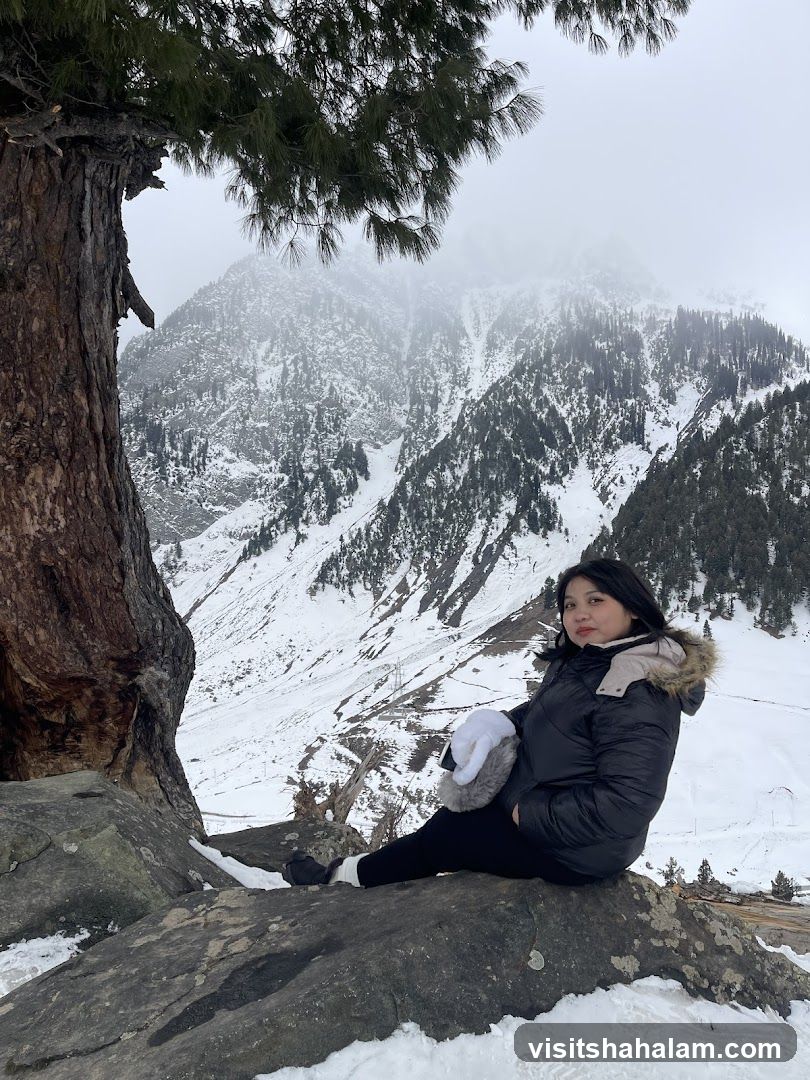 Woman sitting on rocks in snowy mountains