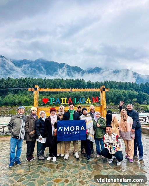 Group posing with a flag in front of a scenic backdrop