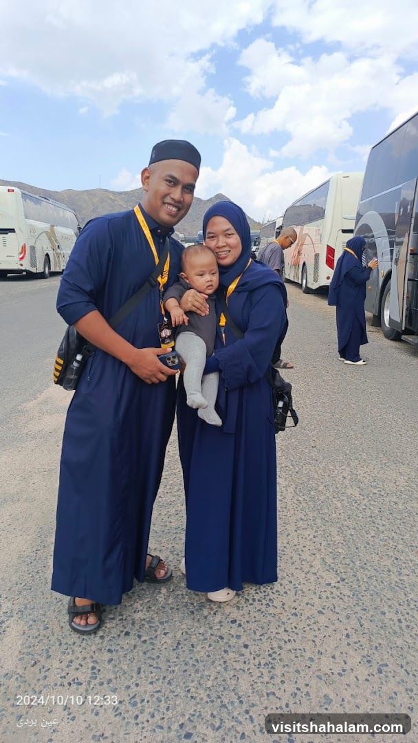 Family posing with buses in the background