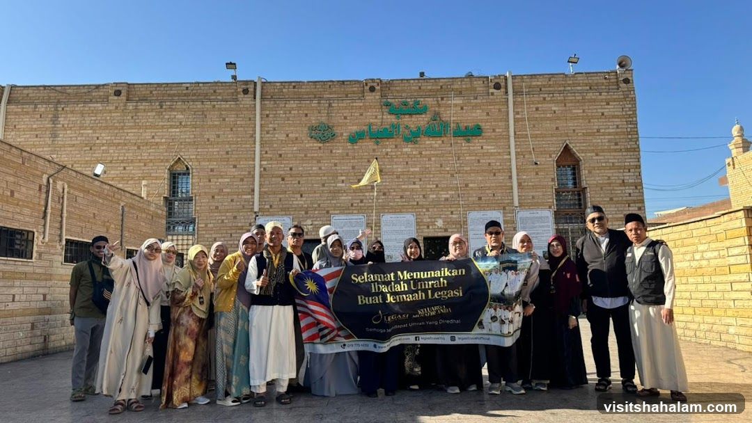 Group posing with banner outside building