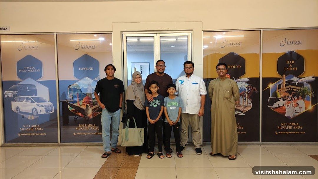 Group posing in front of travel agency advertisements