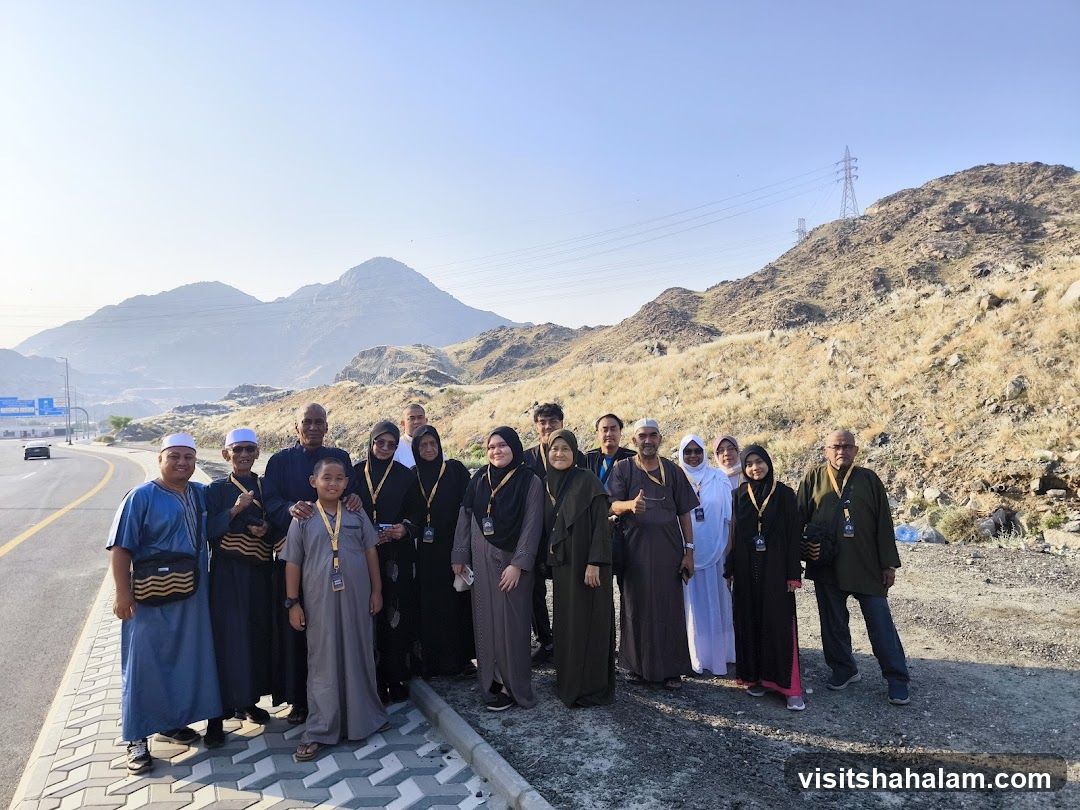 Group of people posing for a photo in a mountainous area