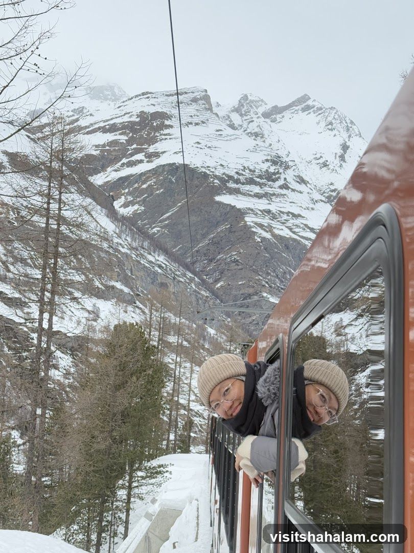 People looking out of train window in snowy mountains