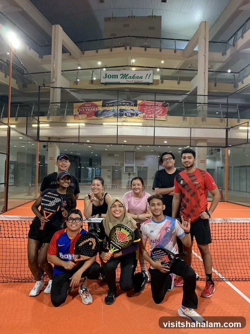 Group of people posing with paddles on a court
