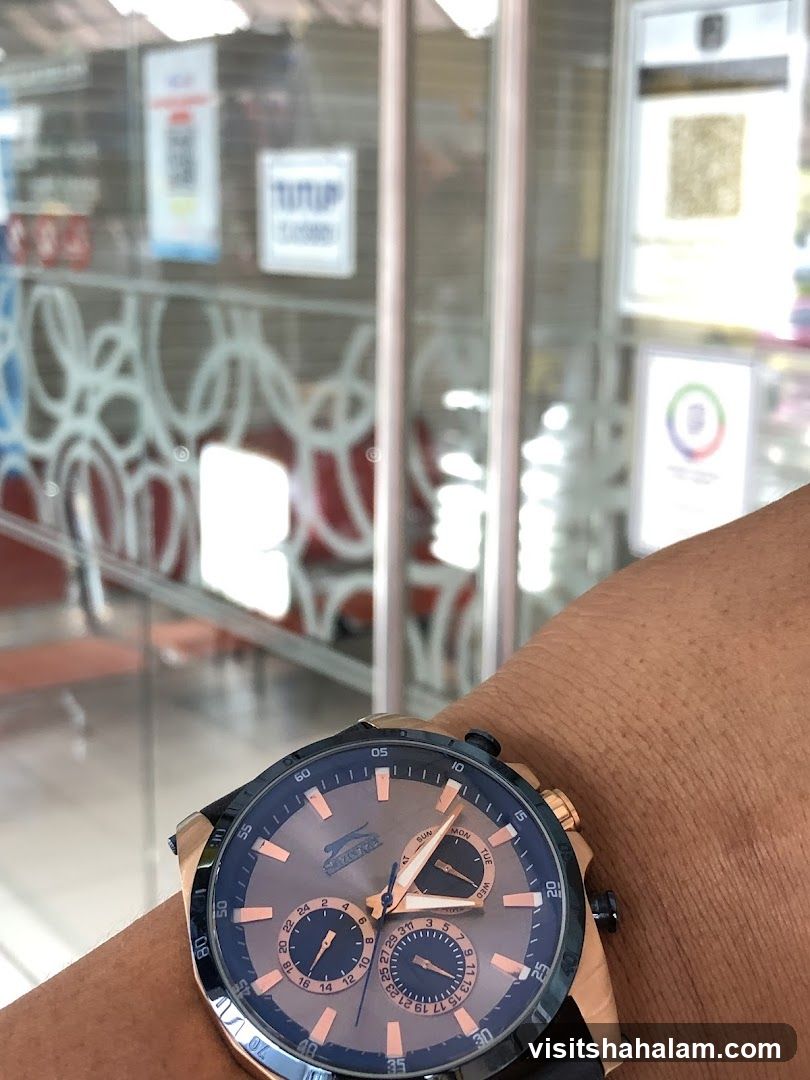 Watch on wrist in front of shop entrance