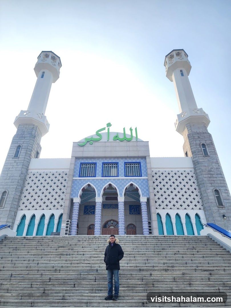 Man standing on steps in front of a mosque