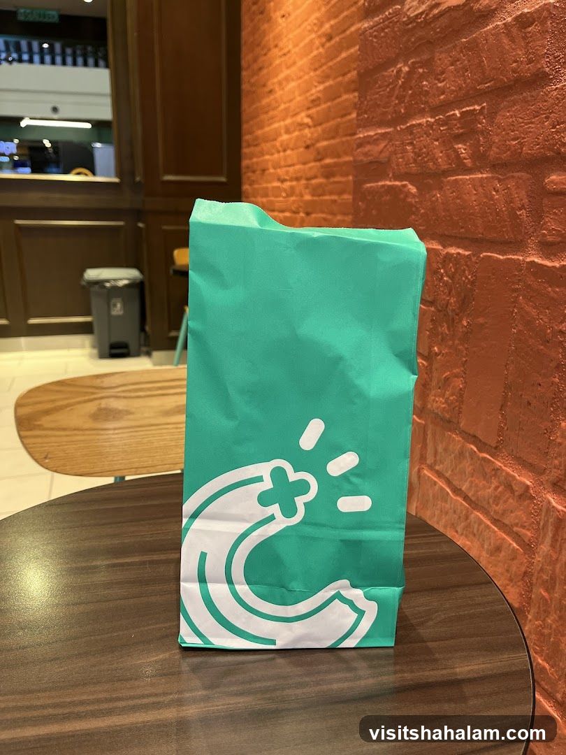 Teal paper bag with white logo on a table