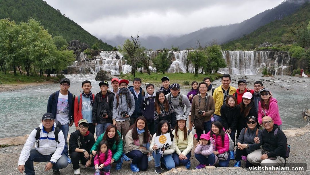 Group posing in front of a waterfall
