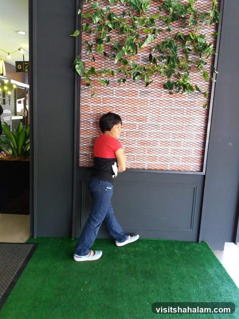Person posing by a decorative wall