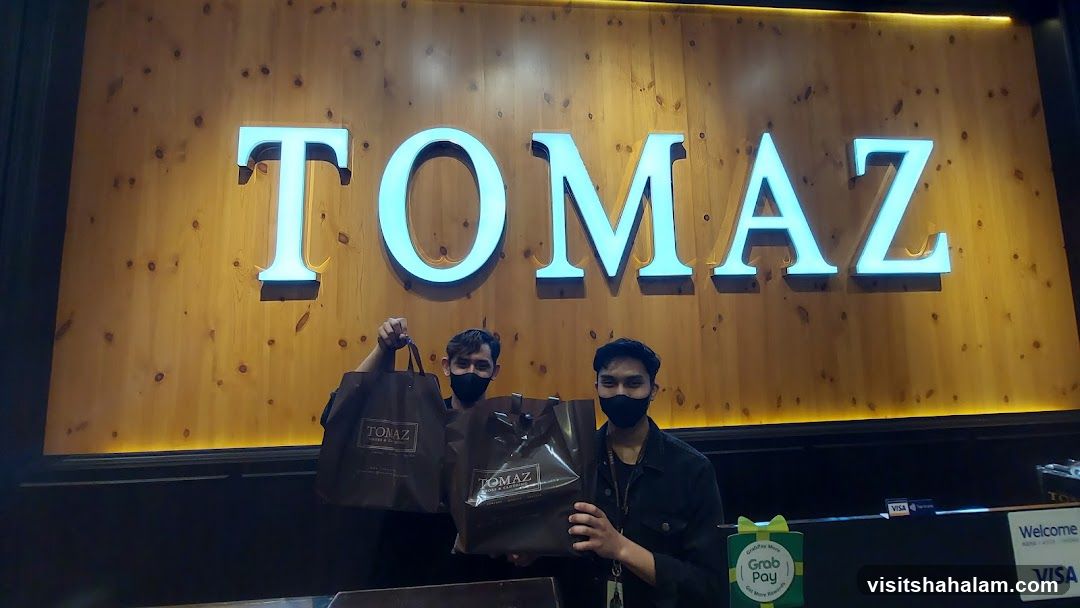 Two men holding shopping bags in front of a store sign