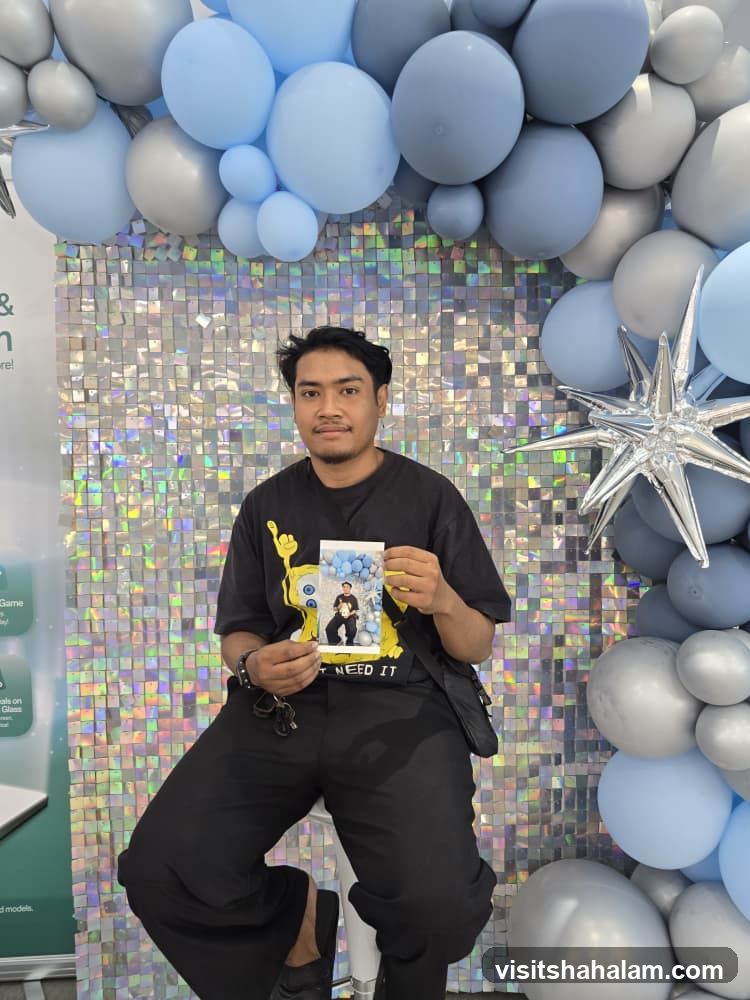 Man holding a photo in front of a balloon arch