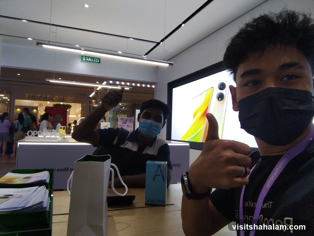 Two men giving thumbs up in an electronics store
