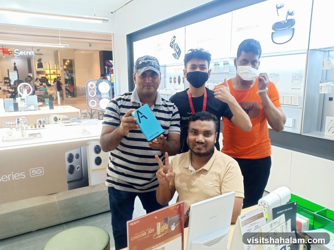Four men posing in an electronics store