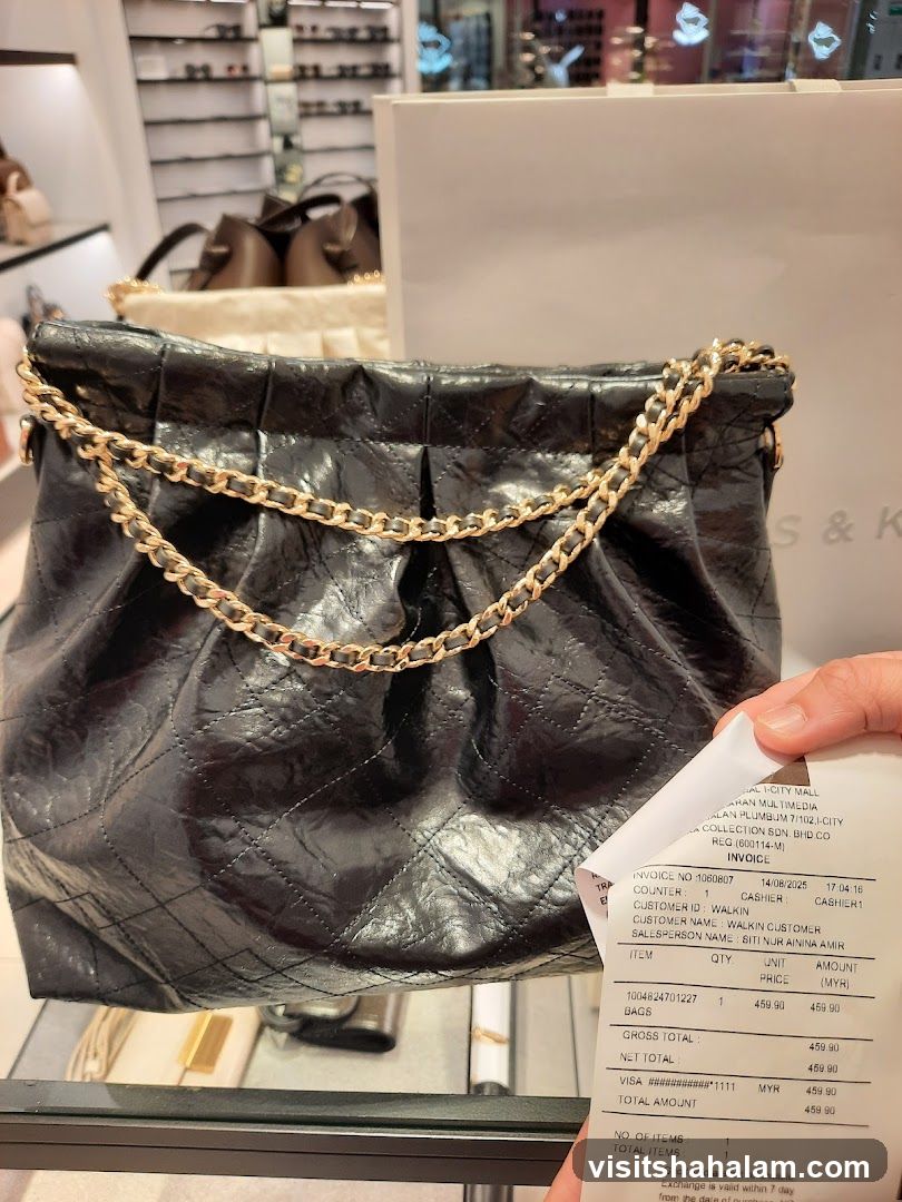 Black quilted handbag with gold chain and receipt