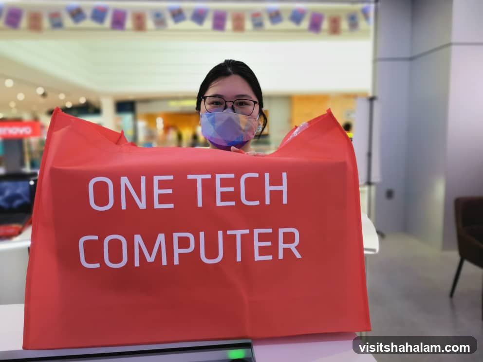 Woman holding a red bag with "ONE TECH COMPUTER" text