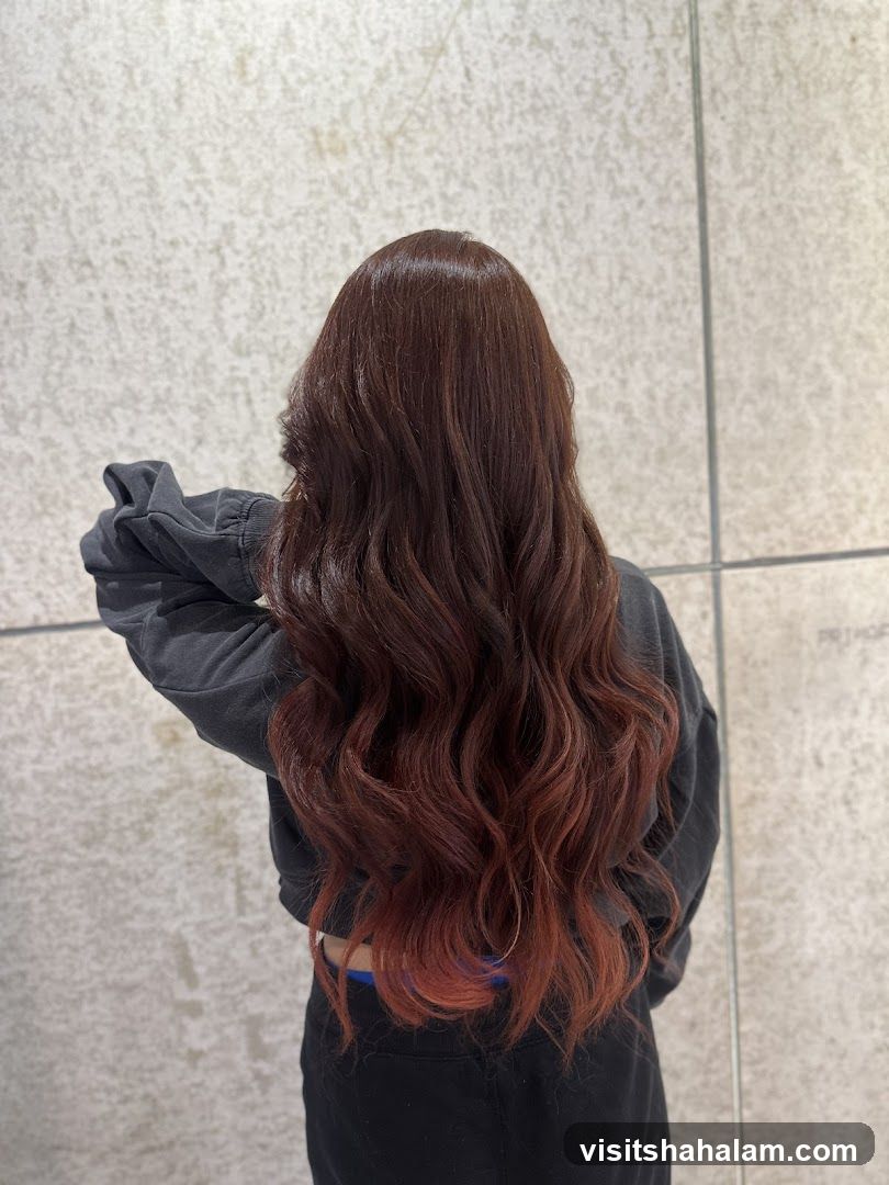Woman with long, wavy, auburn-tinted hair