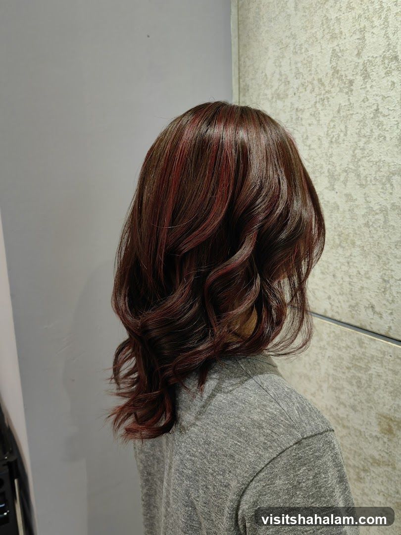 Woman with styled dark hair with red highlights