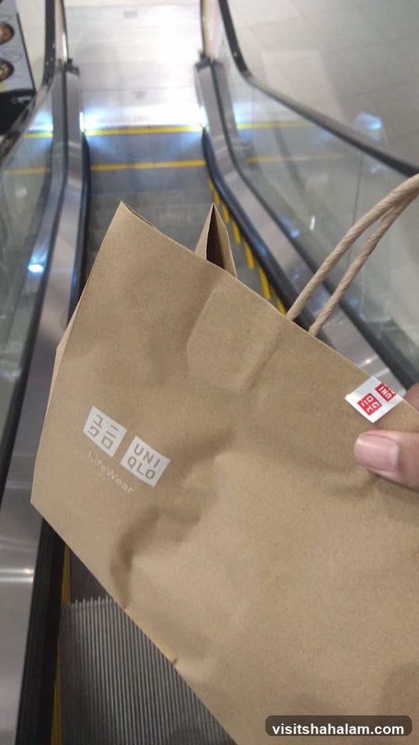 Uniqlo shopping bag on escalator