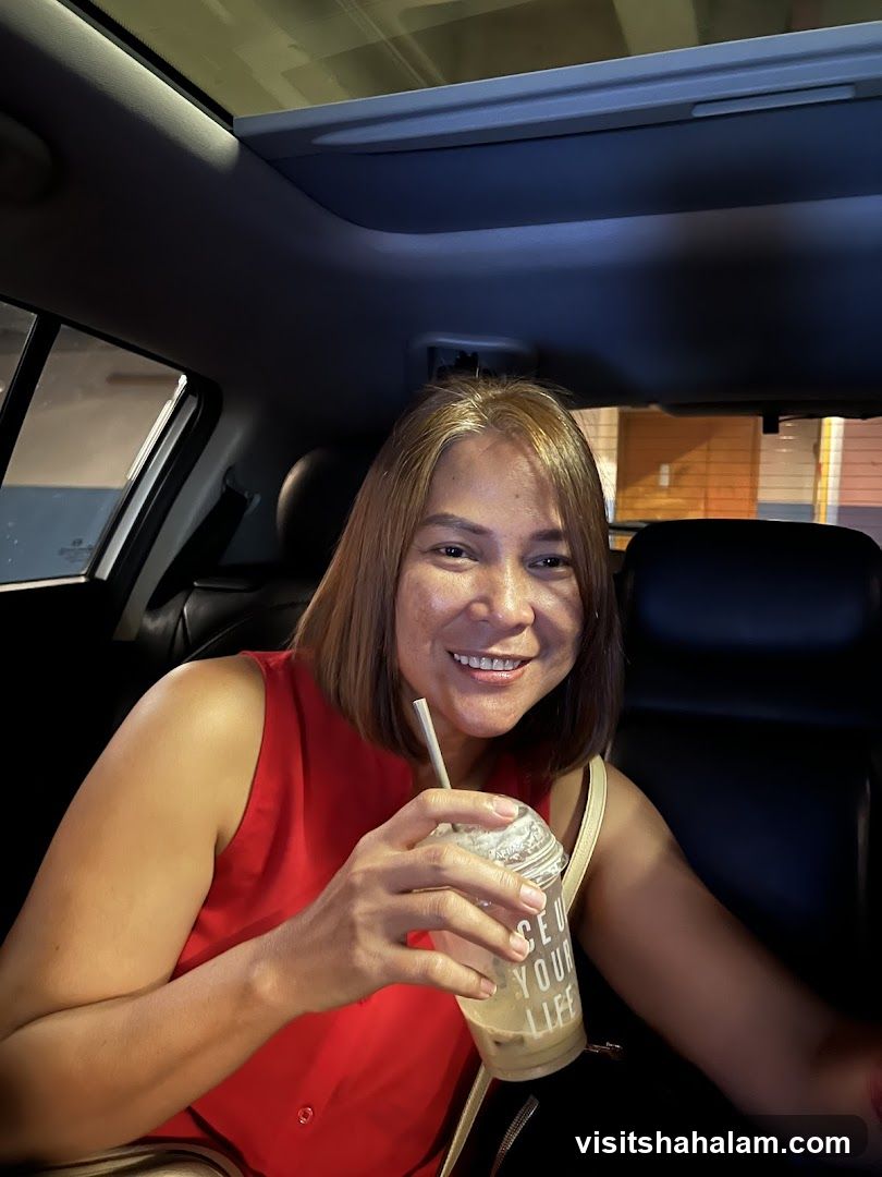 Woman with a drink in a car