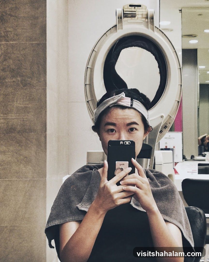 Woman taking a selfie under a hair dryer