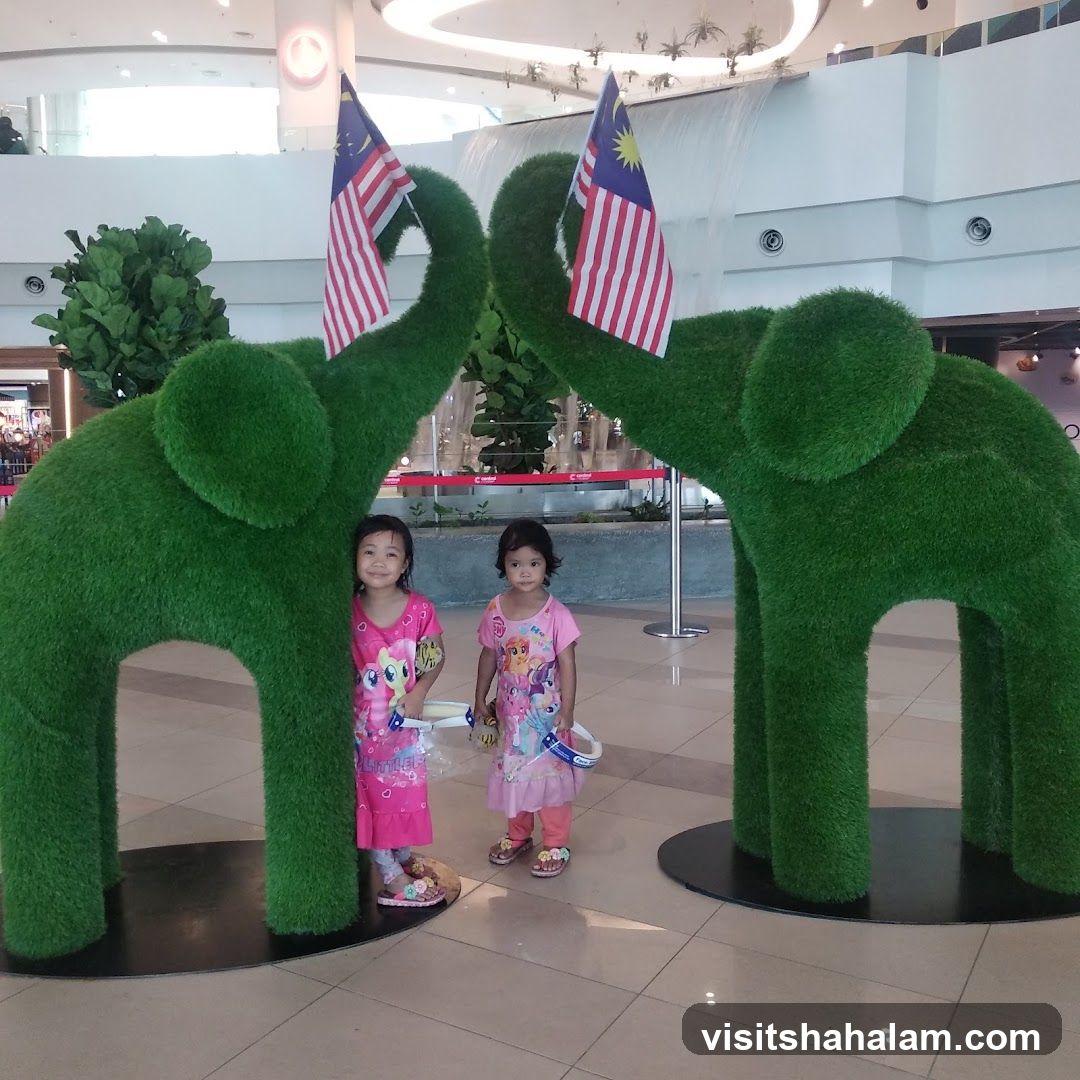 Two girls posing with topiary elephants
