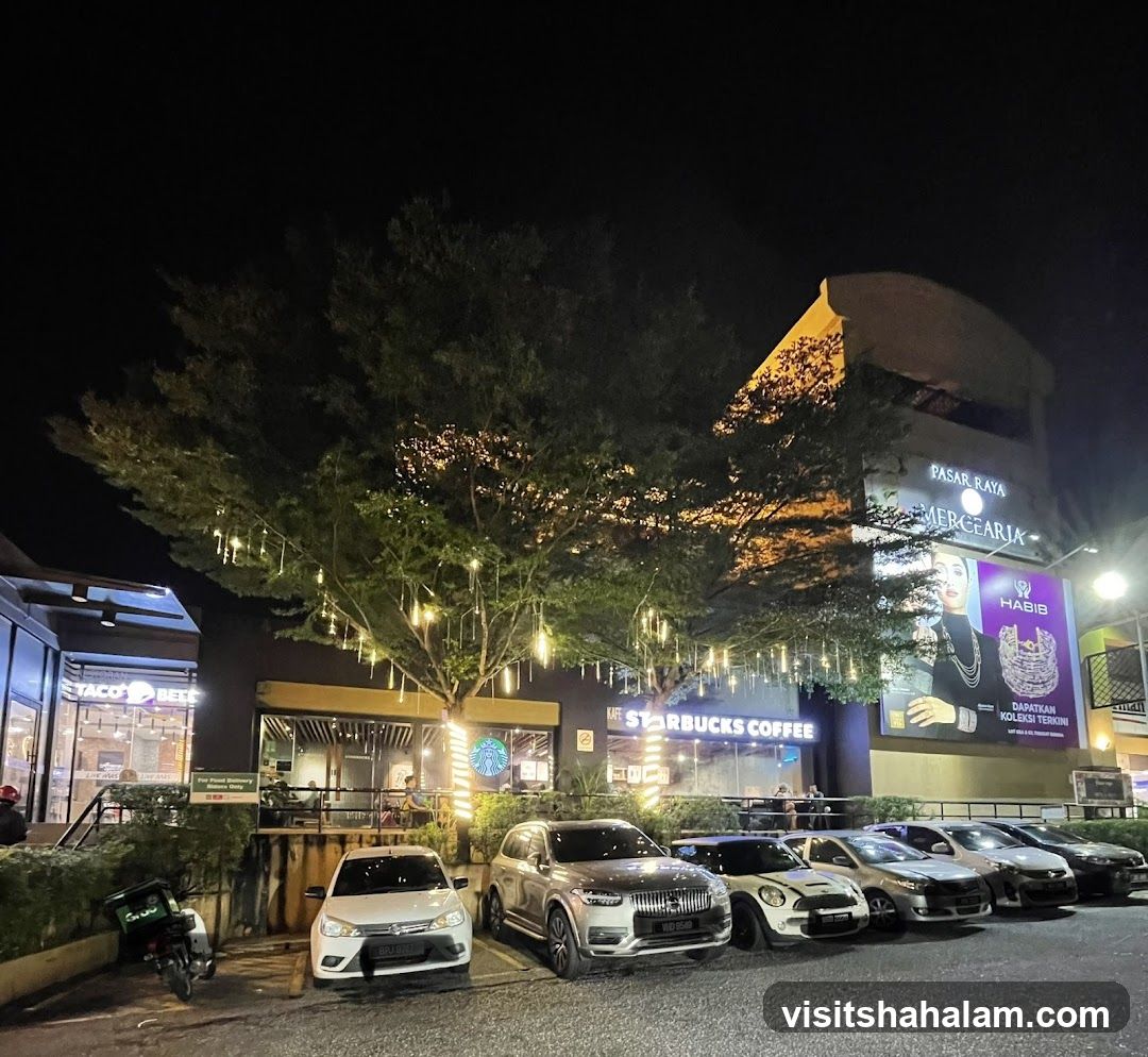 Nighttime street view with shops and cars