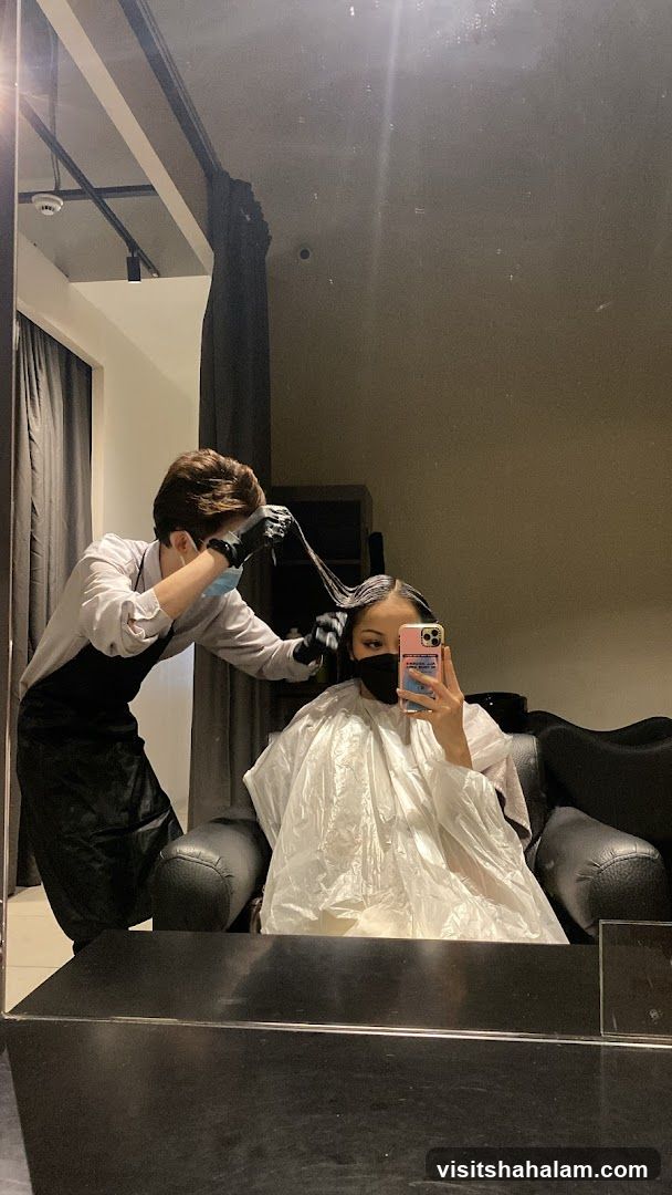 Hairdresser applying treatment to client's hair